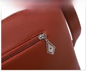 Vue macro du cuir PU grainé marron et du curseur de fermeture éclair en argent