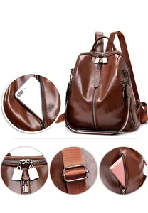 Detail of vintage brown leather backpack showing double zippers and side pocket