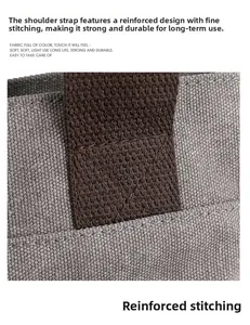 Macro shot of heavy-duty reinforced stitching on grey canvas bag with woven strap detail