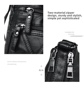 Detail of dual-material zipper pulls and layered pockets on black pebbled leather bag