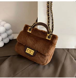 Détail d'un sac à main en peluche marron avec fermoir doré rotatif et bandoulière chaîne