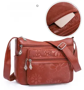 Détail du sac à bandoulière en similicuir gaufré avec plusieurs poches zippées