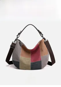 Detail of color-block canvas bag with leather handles and adjustable shoulder strap
