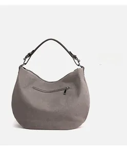 Detail view of the gray canvas hobo bag showing the back zipper pocket and leather strap