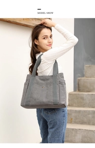 Dettaglio della borsa tote in tela grigia con tasche laterali e bottone in metallo decorativo