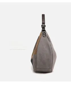 Detail of color-block canvas tote showing leather handles and sturdy side profile