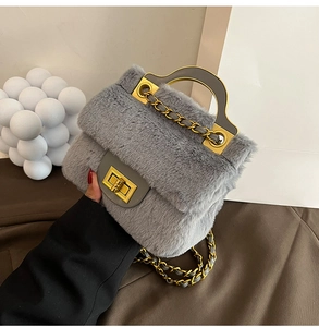 Détail d'un sac à main gris en peluche avec fermoir doré et bandoulière en chaîne