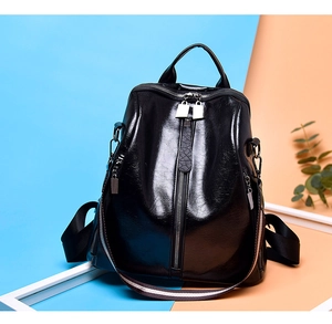 Detail of vintage black leather backpack with striped strap and vertical zipper pocket