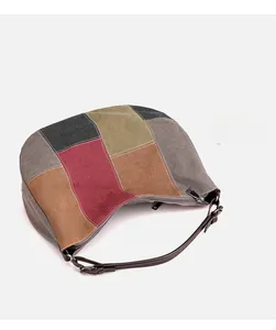 Close-up of color-block canvas hobo bag with patchwork texture and leather strap