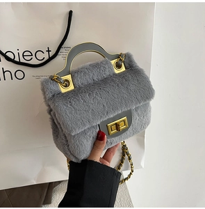 Détail du sac à main en fausse fourrure grise avec fermoir doré et bandoulière chaîne