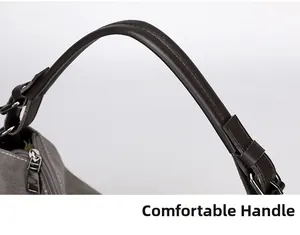 Detail of grey canvas bag showing dark brown leather handle and gunmetal hardware