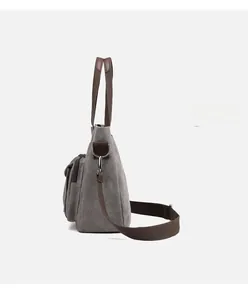 Macro side view of grey canvas tote bag showing D-ring and metal hook for shoulder strap