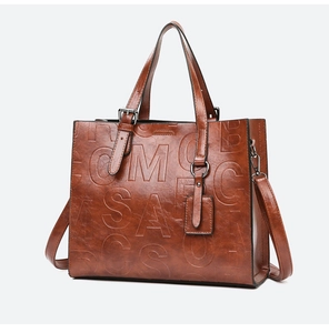 Vue détaillée du sac cabas vintage marron avec lettres gaufrées et bandoulière