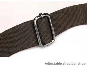 Close-up of adjustable canvas shoulder strap with dark metal buckle on a tote bag