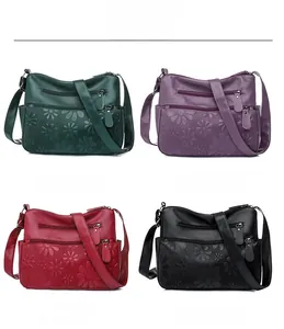 Detailed view of embossed floral patterns on multi-pocket faux leather crossbody bags