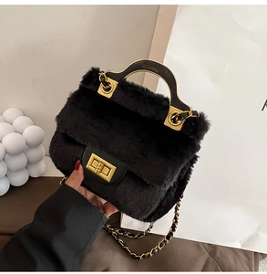 Détail du sac à main en peluche noire avec fermoir doré et bandoulière en chaîne métal