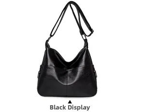 Close-up of black PU leather hobo bag with wide shoulder strap and side metal zippers