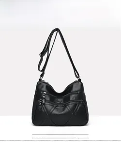 Front view of black soft leather crossbody bag showing three functional zipper compartments