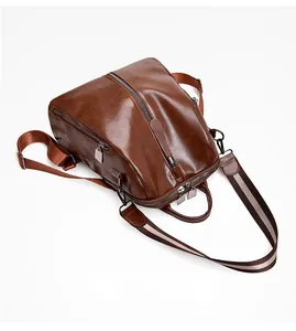 Detailed flat lay of dark brown vintage faux leather backpack with striped webbing straps