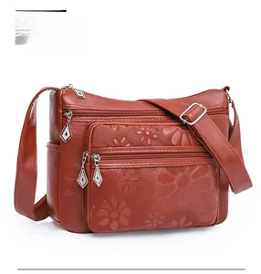 Détail du sac en cuir PU brun rouge avec gaufrage floral et plusieurs fermetures éclair
