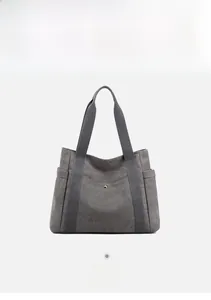 Dettaglio della borsa tote in tela grigio scuro con tasca laterale e trama tessuto