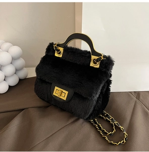 Détail du sac à main en peluche noire avec fermoir rotatif doré et bandoulière en chaîne