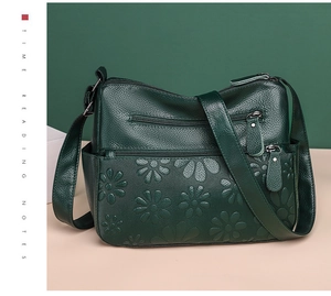 Detail of dark green daisy-embossed leather with functional multi-zipper pockets