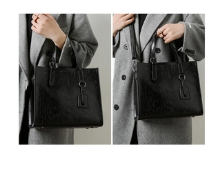 Détails d'un sac cabas noir en cuir brillant avec lettres en relief et métal