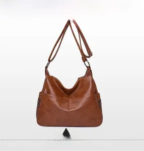 Macro shot of brown faux leather hobo bag showing wrinkled texture and side zipper detail