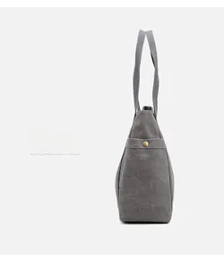 Dettaglio della borsa tote in tela grigia con tasche laterali e bottoni a pressione in ottone