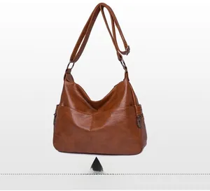 Detail of vintage caramel brown crossbody bag with side zip and textured faux leather