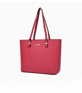 Detail of red tote bag with gold lettering, cross-grain texture and metallic rivets