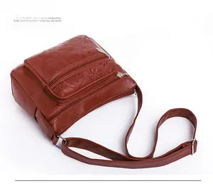 Détail du sac en similicuir marron rouge foncé avec gaufrage floral et multi-compartiments