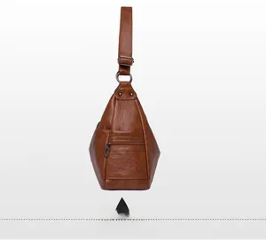 Detail view of brown textured leather shoulder bag with zipper pocket and side pouch