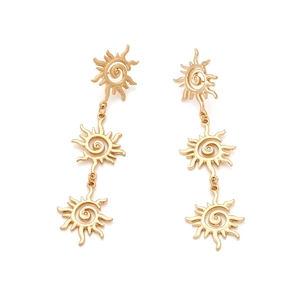 Detail of multi-layered golden sun drop earrings with polished spiral floral charms
