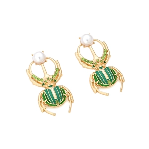 Détail de boucles d'oreilles scarabée dorées avec émail vert et cristaux brillants