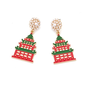 Detail of red and green enamel pagoda earrings with pearl floral studs on white background