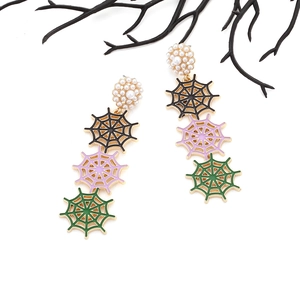 Détail de boucles d'oreilles toile d'araignée avec pendentifs colorés et perles