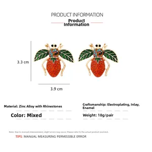 Detail of bee earrings with strawberry body, green wings, and colorful crystals