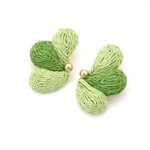 Detail of handmade raffia woven leaf earrings with green gradient and gold bead accents