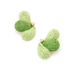 Detail of handmade raffia fan earrings featuring green gradient woven leaf patterns