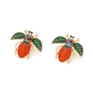 Detail of bee earrings with strawberry body, green leaf wings and colorful crystals