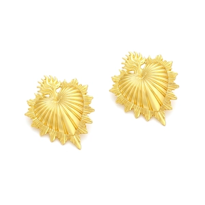 Macro detail of vintage gold Sacred Heart earrings with textured radial striped pattern