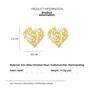 Detail of vintage gold hollow heart earrings with faux pearl inlay and 3.6cm size