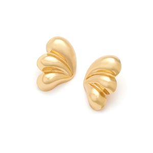 Détails macro des boucles d'oreilles feuilles dorées en éventail avec finition polie