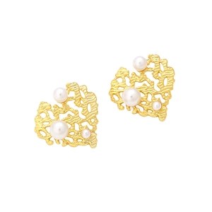 Detailed macro of vintage gold-plated heart earrings with lava texture and faux pearls