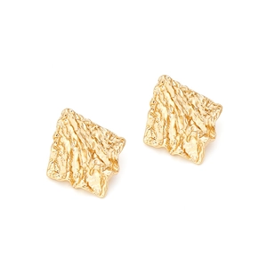 Close-up of golden geometric earrings featuring textured crumpled metal finish