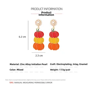 Détail macro de boucles d'oreilles citrouille montrant la taille de 6,2 cm et l'émail