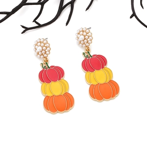 Détail macro de boucles d'oreilles citrouille d'Halloween en émail coloré et perles