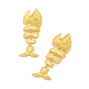 Detailed close-up of golden fishbone earrings with vintage matte metallic texture
